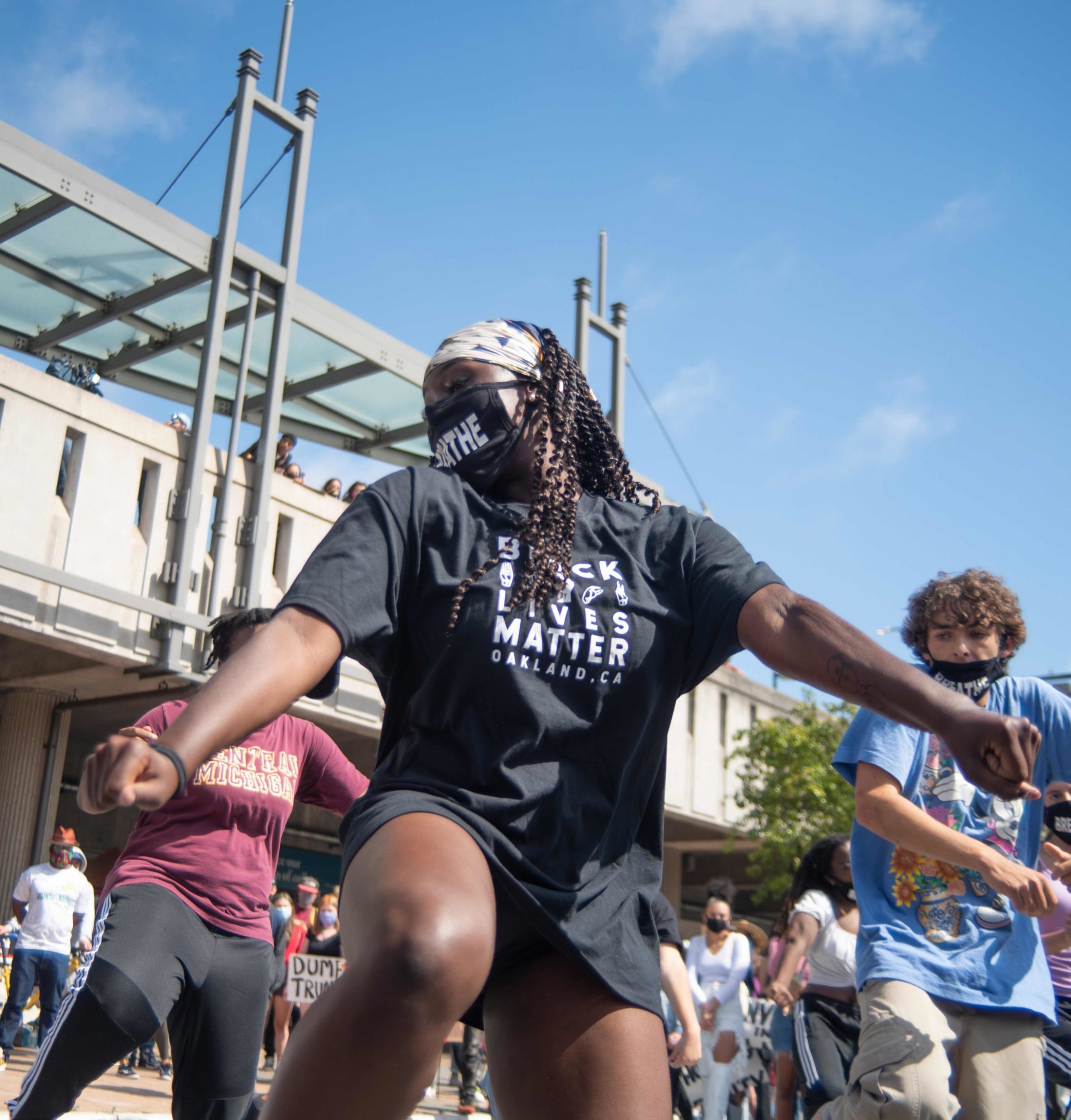 Person in a black t-shirt and a mask dancing with a group